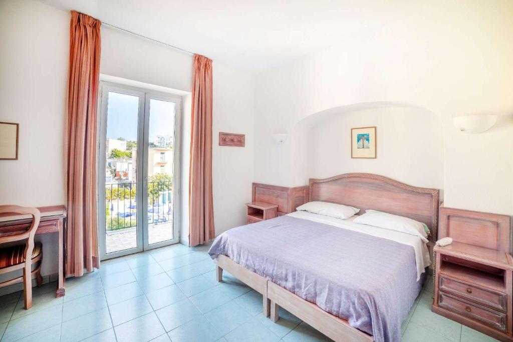 une chambre avec un lit et une grande fenêtre dans l'établissement Hotel Royal Terme, à Ischia