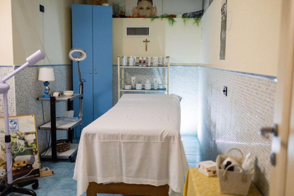 une salle d'hôpital avec un lit et une croix sur le mur dans l'établissement Hotel Royal Terme, à Ischia