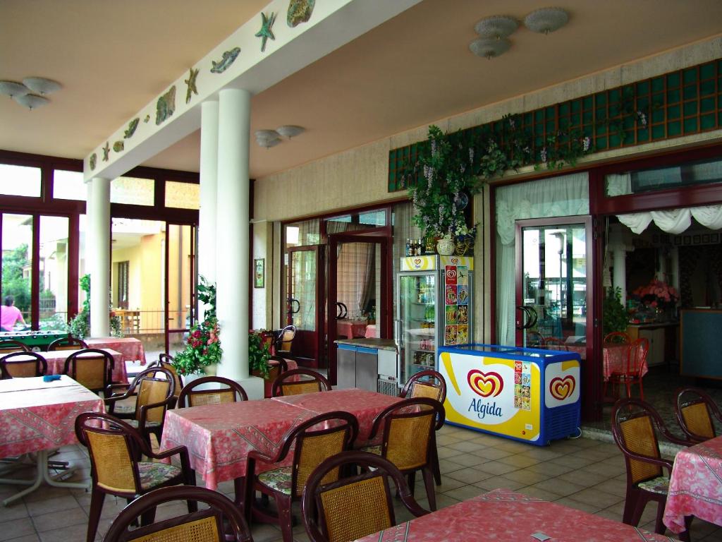 un restaurant vide avec des tables, des chaises, des tables et des tables dans l'établissement Hotel Villa Dina, à Lido di Jesolo