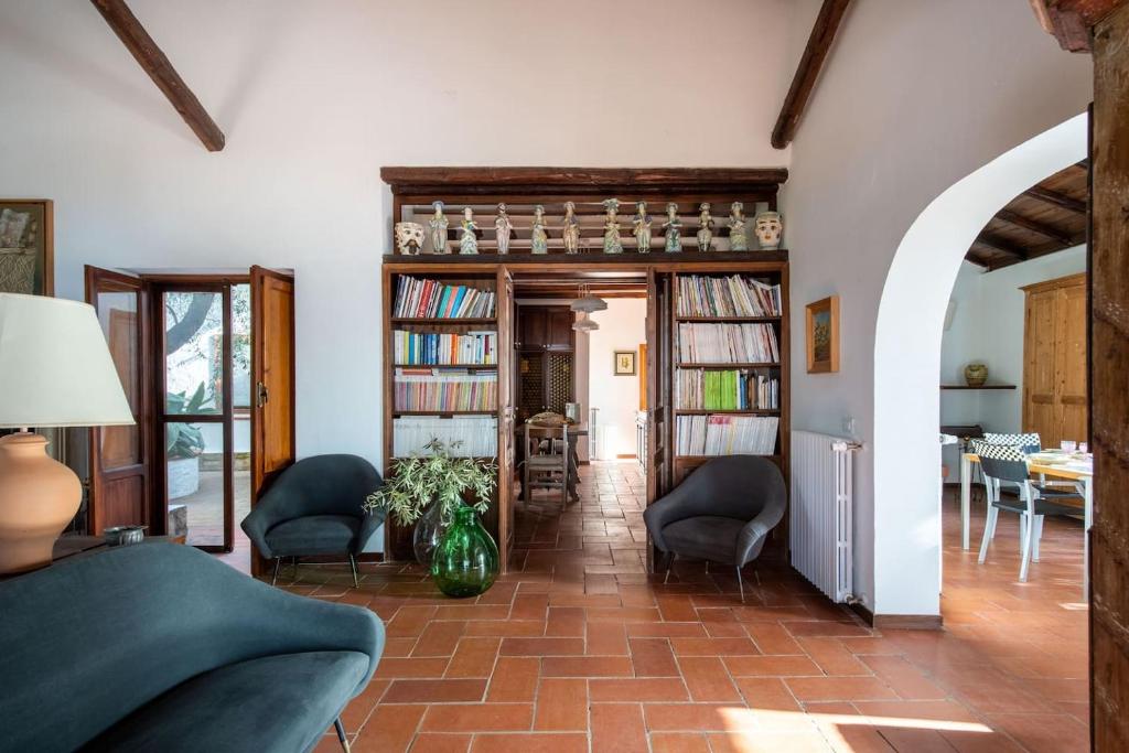 - un salon avec un canapé, des chaises et des étagères dans l'établissement Villa Grimodi, à Caronia Marina