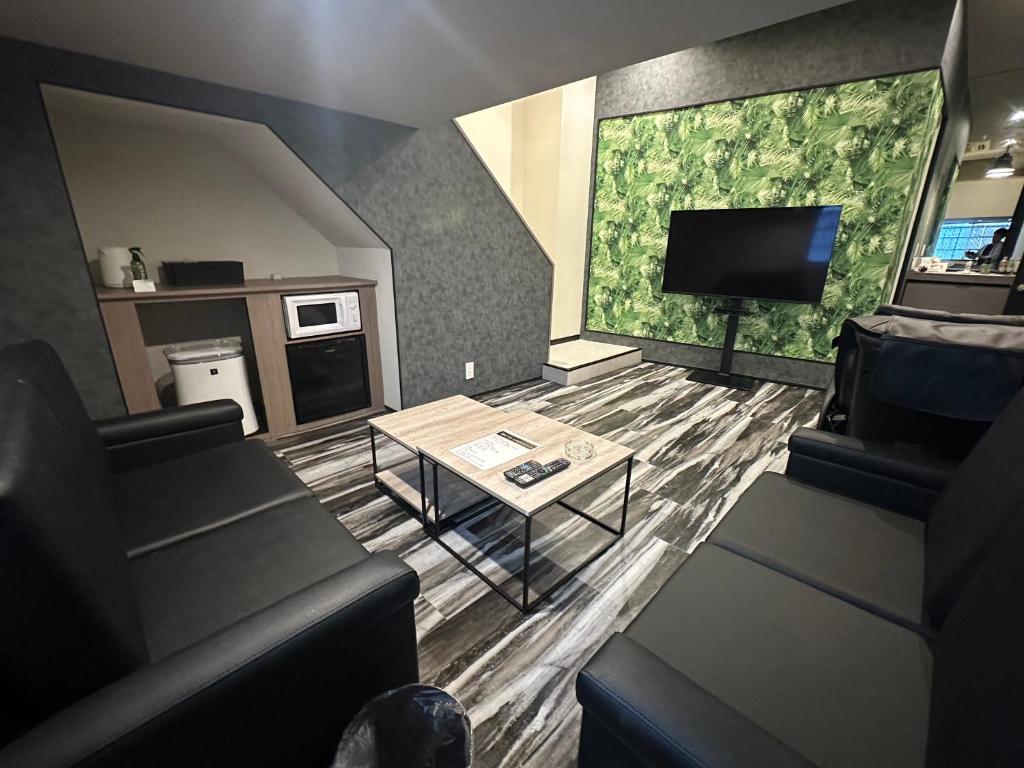 un salon avec un canapé et une télévision dans l'établissement grandir ｸﾞﾗﾝﾃﾞｨｰﾙ-Adult Only-, à Yokohama
