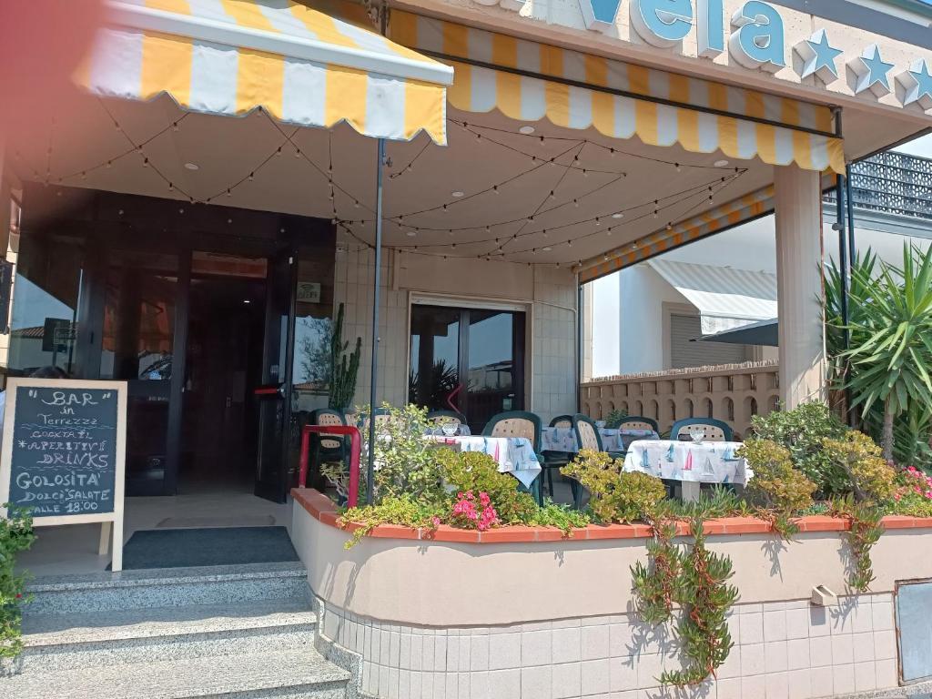 un restaurant avec une table et des chaises devant dans l'établissement Hotel La Vela, à Lido di Camaiore