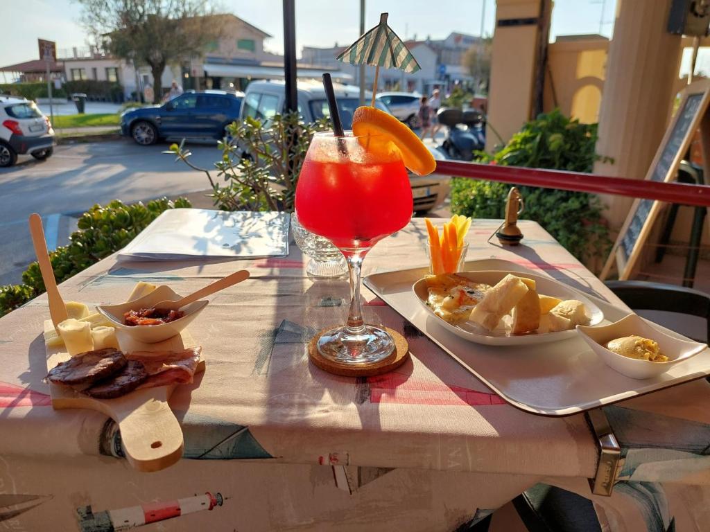 - une table avec une boisson et une assiette de nourriture dans l'établissement Hotel La Vela, à Lido di Camaiore