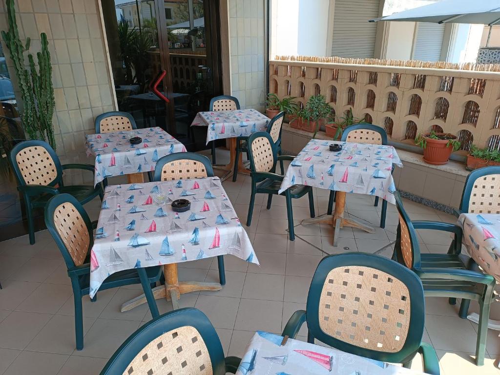 une rangée de tables et de chaises dans un restaurant dans l'établissement Hotel La Vela, à Lido di Camaiore