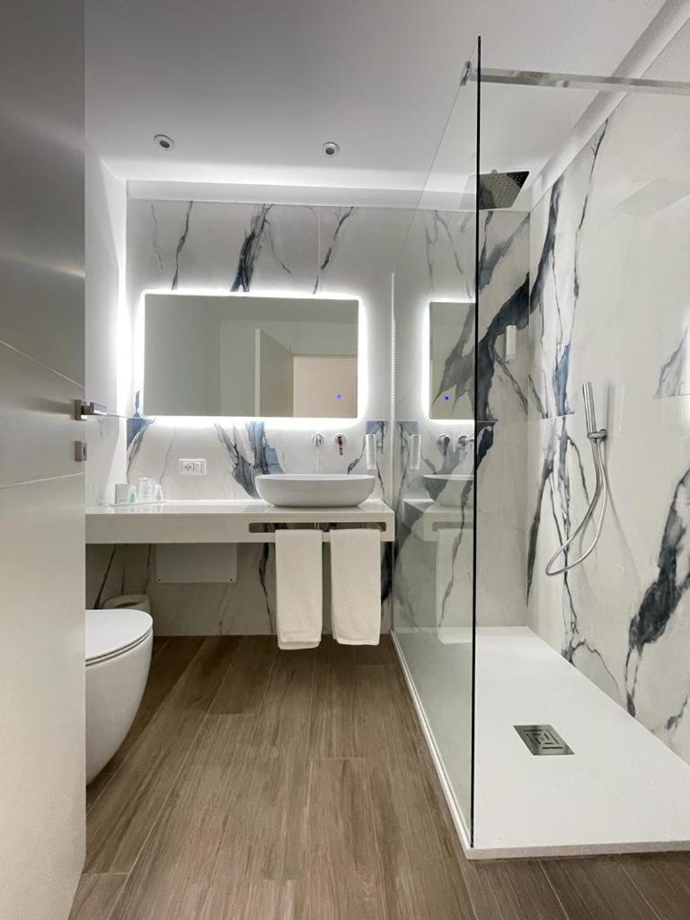 une salle de bain avec toilettes, lavabo et miroir dans l'établissement Rodi Resort, à Rodi Garganico