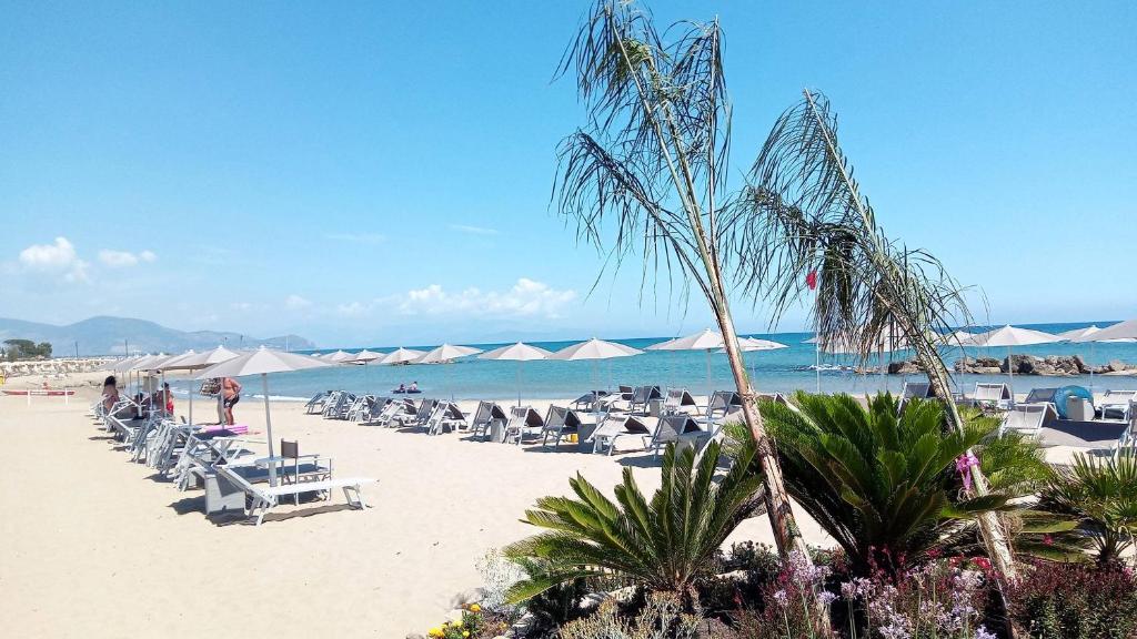 une plage avec des chaises et des parasols et l'océan dans l'établissement Hotel Mercede 2, à San Felice Circeo
