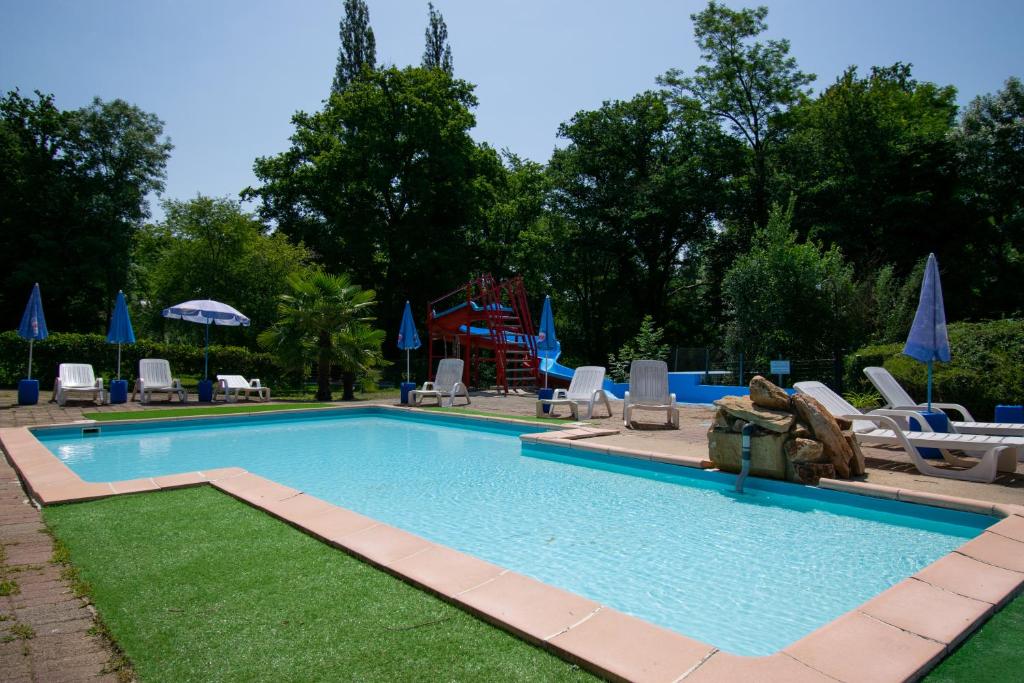 - une piscine avec des chaises et un toboggan dans l'établissement Camping des Bains, à Saint-Honoré-les-Bains