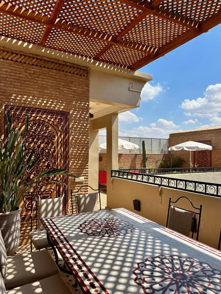 un patio avec une table et des chaises sur un balcon dans l'établissement RIAD SHAJARA, à Marrakech