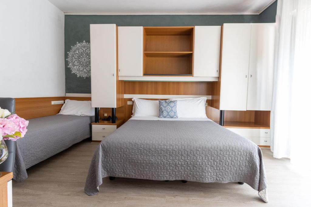 - une chambre avec 2 lits avec des placards blancs dans l'établissement Hotel Crystal, à Caorle