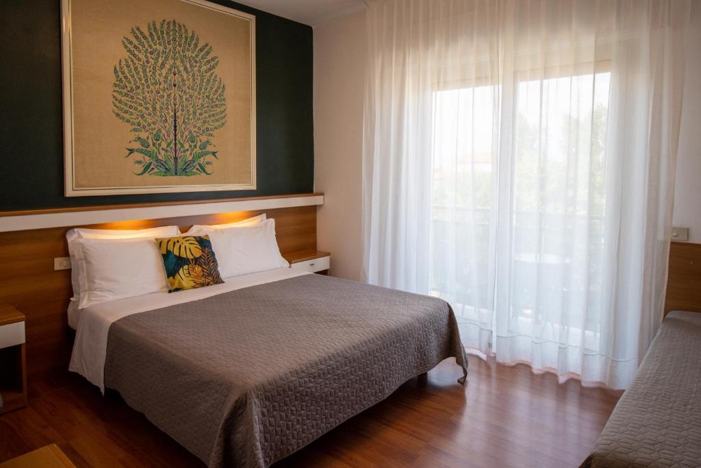une chambre avec un lit et une grande fenêtre dans l'établissement Hotel Crystal, à Caorle