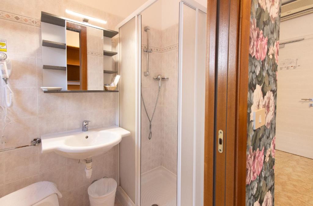 une salle de bain avec douche, lavabo et toilettes dans l'établissement Hotel Crystal, à Caorle