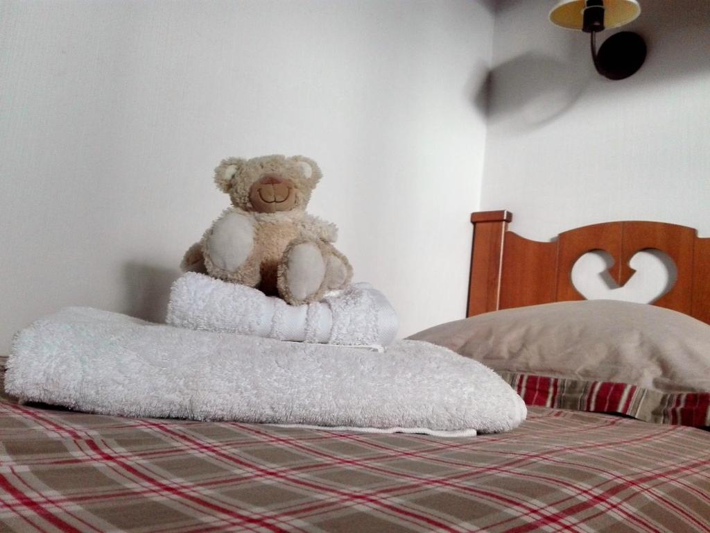 un ours en peluche assis sur un lit dans l'établissement Appartement 2P Isola 2000, à Isola 2000 13 autres photos