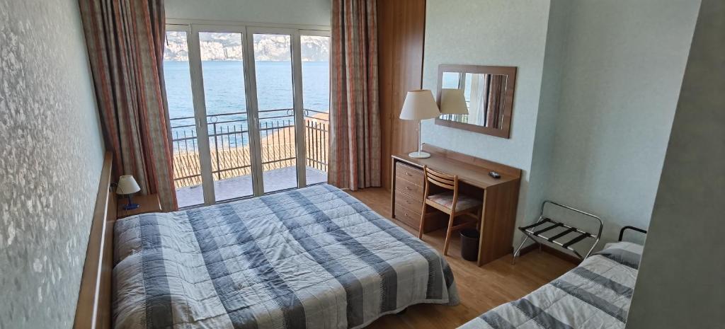 une chambre d'hôtel avec un lit et un balcon dans l'établissement Hotel Nike, à Brenzone