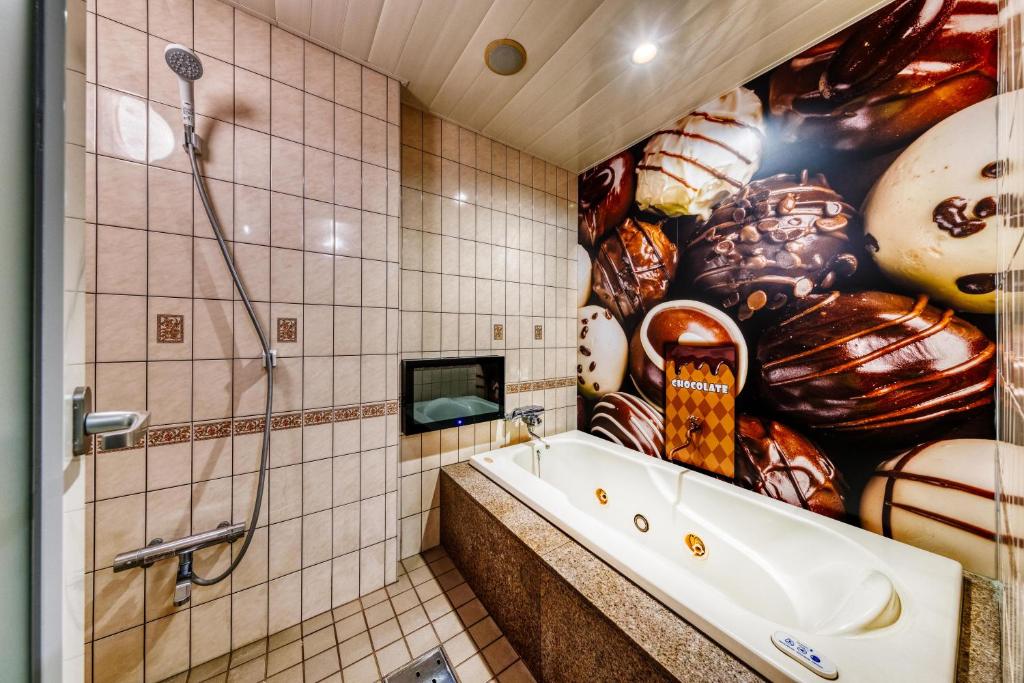 La salle de bains est pourvue d'une baignoire et d'une grande peinture murale. dans l'établissement SWEETS HOTEL KYOTO -Adult Only, à Yawata 11 autres photos