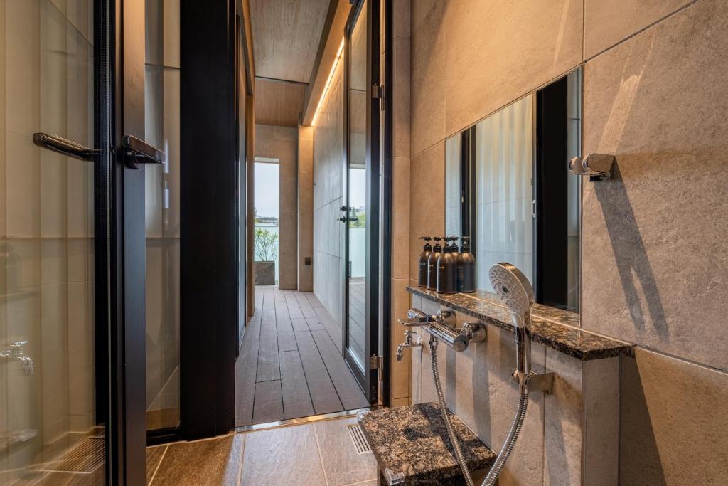 une salle de bain avec une douche à l'italienne et un lavabo dans l'établissement Arima Onsen ShikinoIrodori Hatago, à Kobe
