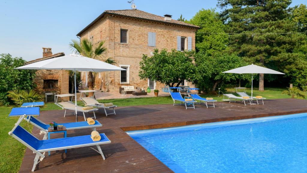 - une piscine avec des chaises et des parasols à côté d'une maison dans l'établissement VILLA RUSTICA 8, Emma Villas, à San Pietro in Vincoli