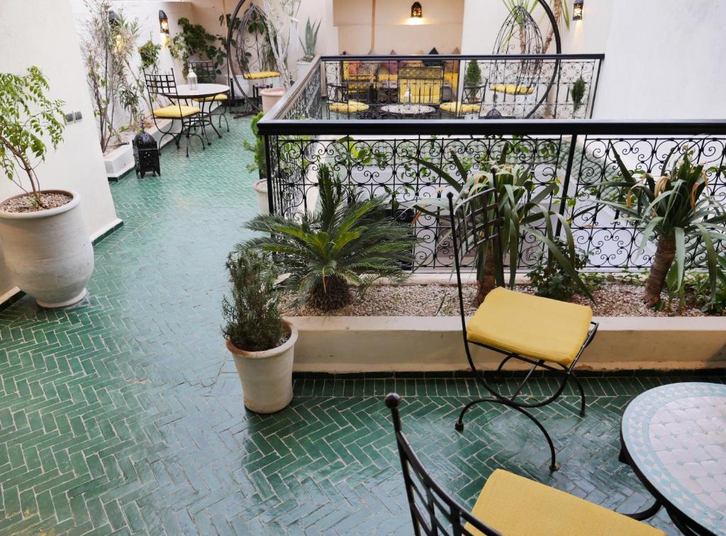 un patio avec des tables, des chaises et des plantes dans un bâtiment dans l'établissement SARDINAS & CHILI, à Marrakech