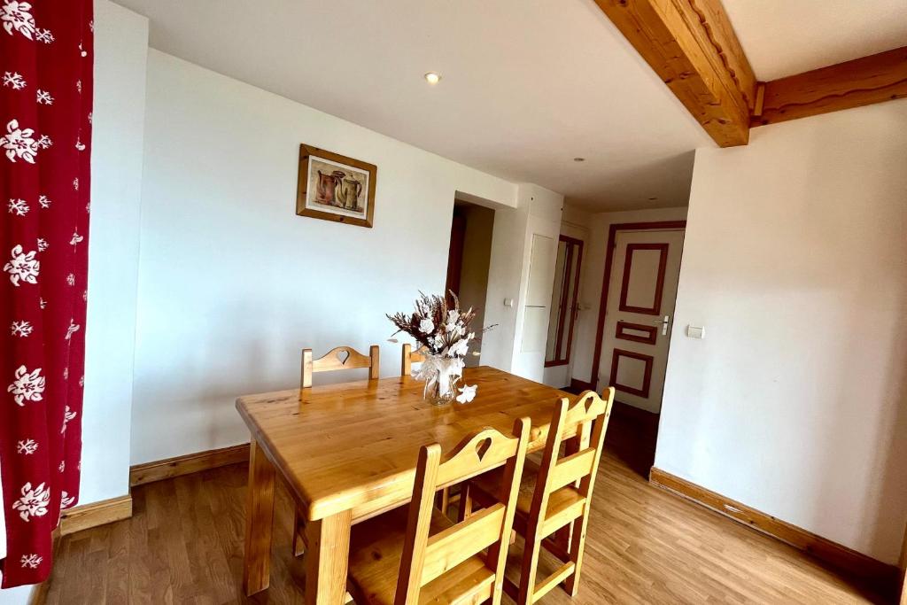 une salle à manger avec une table et des chaises en bois dans l'établissement Bright 50 m cocoon with balcony in Combloux, à Combloux