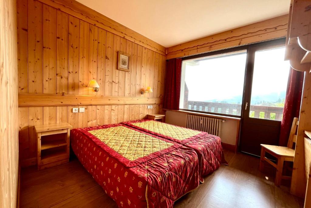une chambre avec un lit et une grande fenêtre dans l'établissement Bright 50 m cocoon with balcony in Combloux, à Combloux