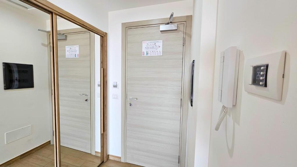 - une porte de douche en verre dans une chambre avec un miroir dans l'établissement Aparthotel Codex, à Rossano