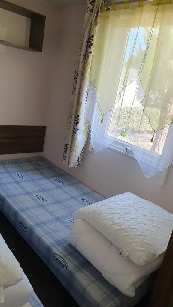une petite chambre avec un lit et une fenêtre dans l'établissement Aux flamants rose, à Saint-Jean-de-Monts