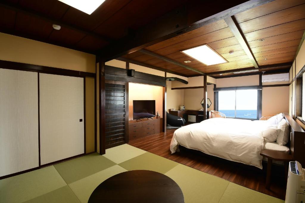 une chambre avec un lit et une télévision dans l'établissement 黒潮の宿 臨海荘 -Kuroshio no yado Rinkaisou-, à Katsuura 46 autres photos