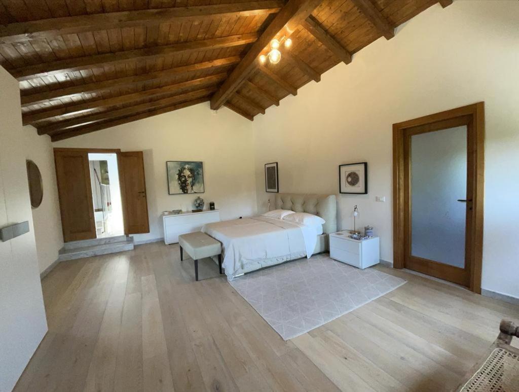 - une chambre avec un lit blanc et un plafond en bois dans l'établissement Casale del Pozzo-Villa with pool - Fosdinovo in the borgo of Pulica, à Tendola 67 autres photos