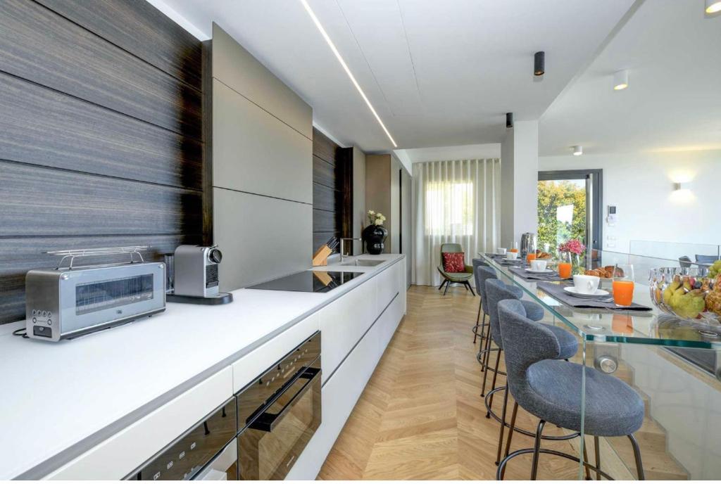 une cuisine avec comptoir et tabourets de bar dans l'établissement Villa Diamante del Garda & Spa, à Toscolano Maderno