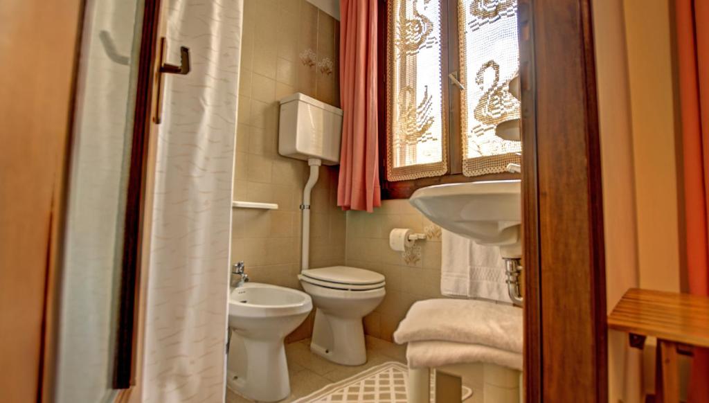 une petite salle de bain avec toilettes et lavabo dans l'établissement Albergo Casa Este, à Brenzone
