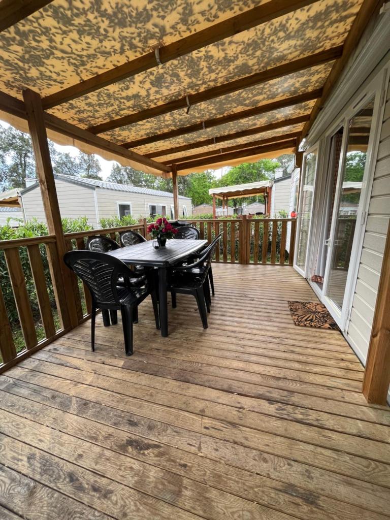 un patio avec une table et des chaises sur une terrasse dans l'établissement Mobil home climatisé, à Lège-Cap-Ferret