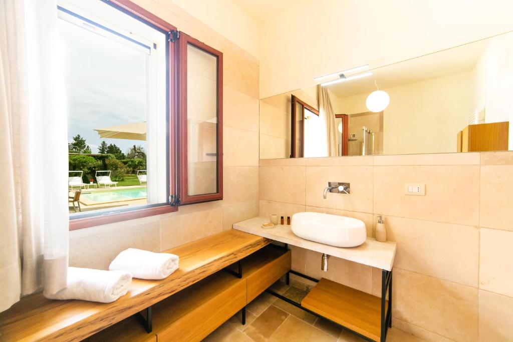une salle de bain avec un lavabo et une fenêtre dans l'établissement Podere Corda di Lana, à Leverano