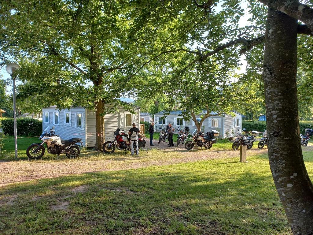 un groupe de motocycles garés sur un chemin de terre dans l'établissement Camping Les Feuilles Chauffailles, à Chauffailles