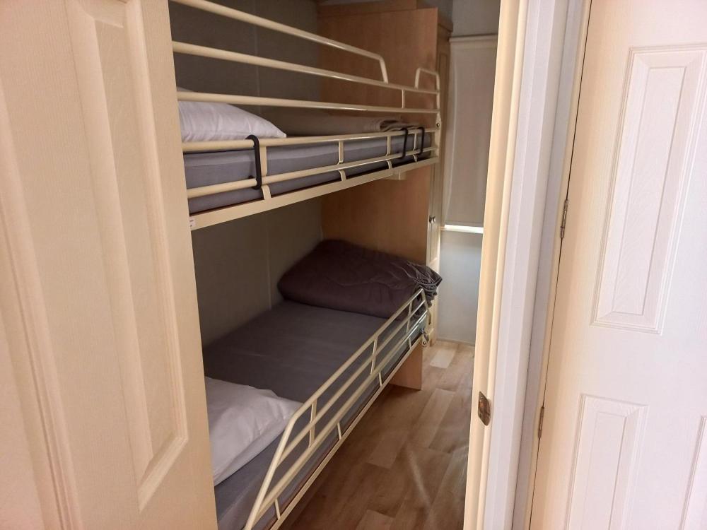 Cette chambre comprend un placard avec 3 lits superposés. dans l'établissement Camping Les Feuilles Chauffailles, à Chauffailles 37 autres photos