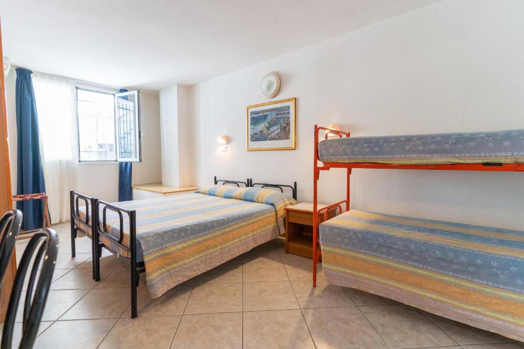 une chambre avec deux lits et un lit superposé dans l'établissement Hotel Villa Isola, à Rimini