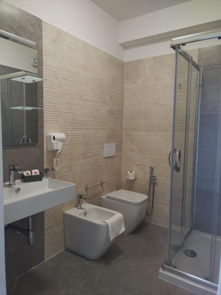 une salle de bain avec toilettes, lavabo et douche dans l'établissement Sand Hotel, à Botricello