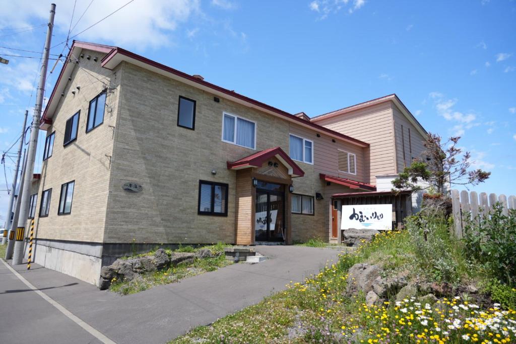 une grande maison avec un bâtiment dans une rue dans l'établissement Shimanoyado Kamuirishiri, à Rishirifuji