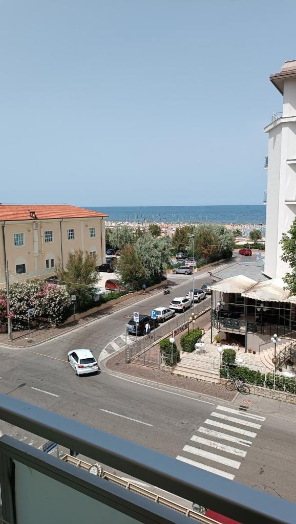une vue d'une rue avec des voitures garées dans un parking dans l'établissement Hotel Sole Mio, à Rimini