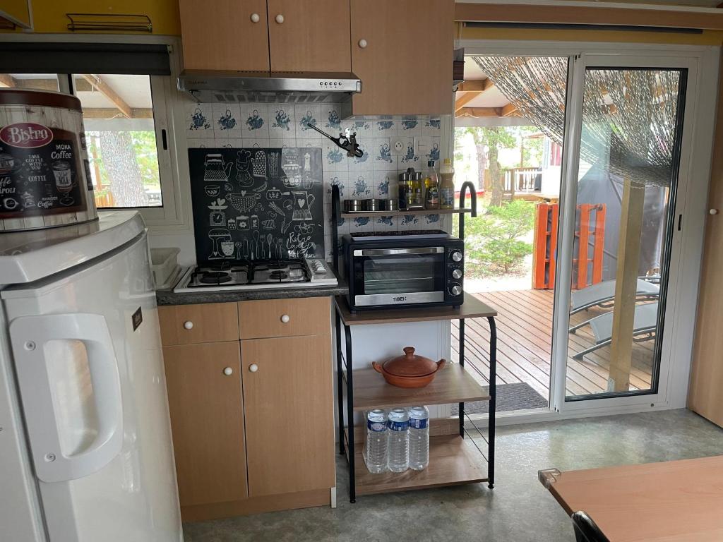 une cuisine avec une cuisinière et un micro-ondes dans l'établissement Mobilhome à Sainte Croix Du Verdon, à Sainte-Croix-de-Verdon