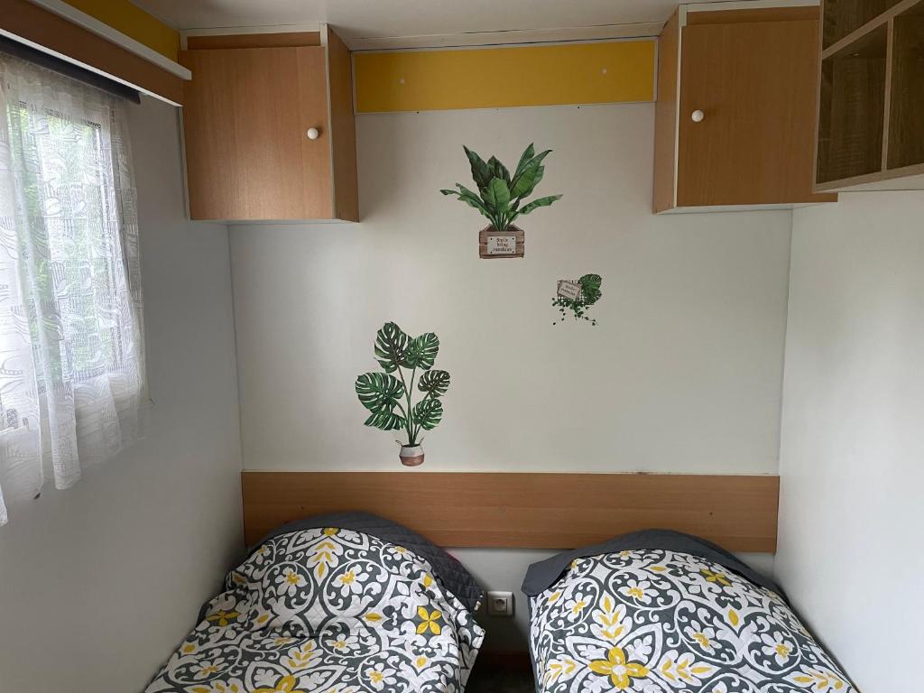 un coin d'une pièce avec deux oreillers et des plantes sur le mur dans l'établissement Mobilhome à Sainte Croix Du Verdon, à Sainte-Croix-de-Verdon 9 autres photos