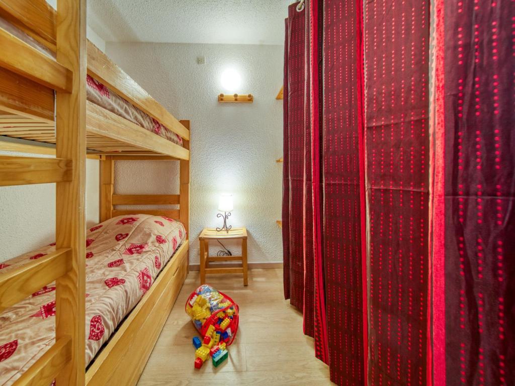 - une chambre avec 2 lits superposés et des rideaux rouges dans l'établissement Apartment Lunik Orion-38 by Interhome, au Corbier