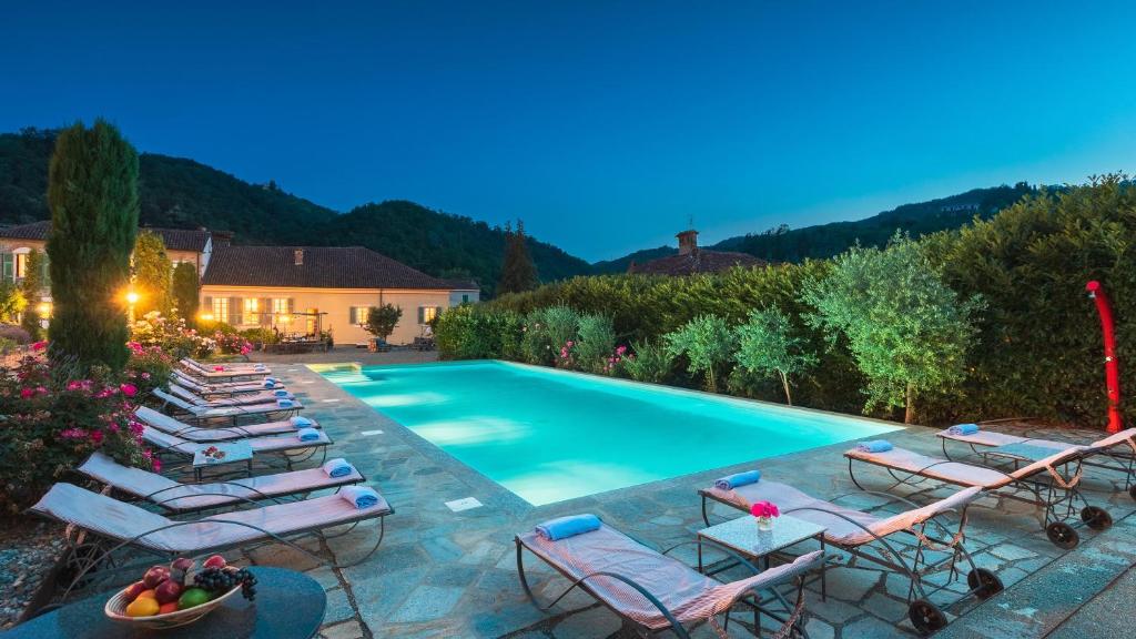 une piscine avec des chaises longues et un tas de meubles dans l'établissement Villa La Romantica 14, Emma Villas, à Grognardo