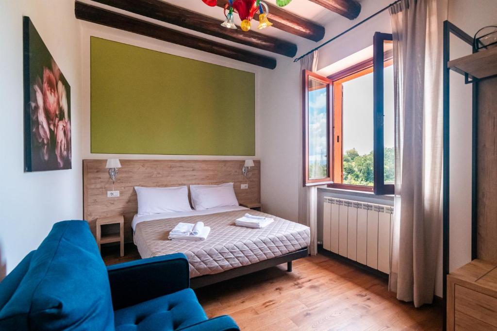une chambre avec un lit et un canapé bleu dans l'établissement Villa La Pieve, à Città della Pieve