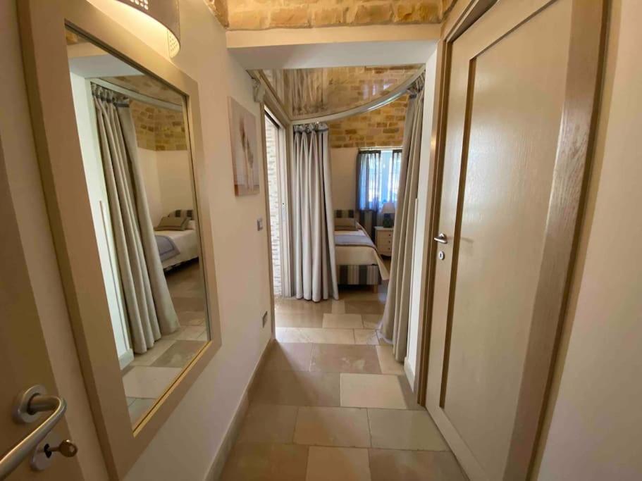 un couloir avec un grand miroir et une chambre dans l'établissement VERDEACQUA HOUSE, à Locorotondo