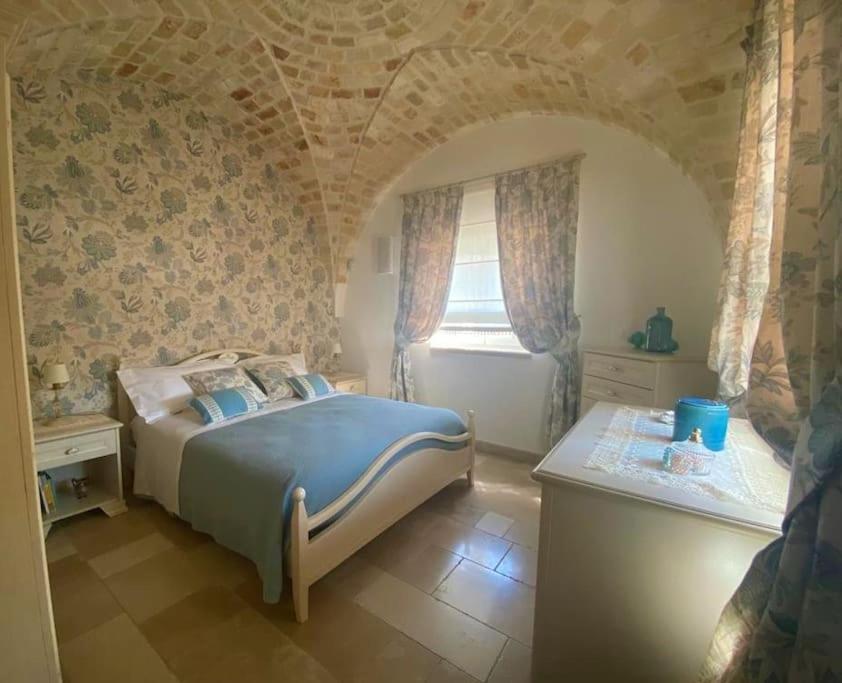 une chambre avec un grand lit et une fenêtre dans l'établissement VERDEACQUA HOUSE, à Locorotondo