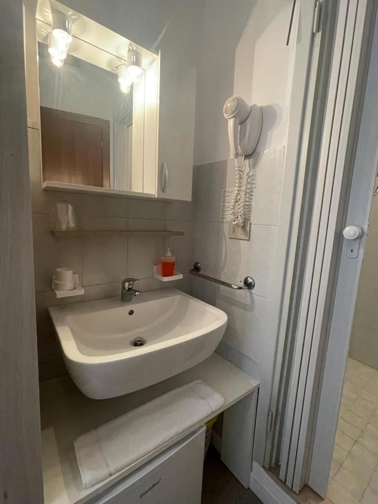 une salle de bain avec un lavabo blanc et un miroir dans l'établissement Hotel & Aparthotel Carinthia S, à Lido di Jesolo