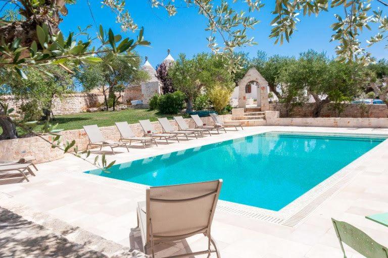 - une piscine avec des chaises longues dans la cour dans l'établissement VERDEACQUA HOUSE, à Locorotondo