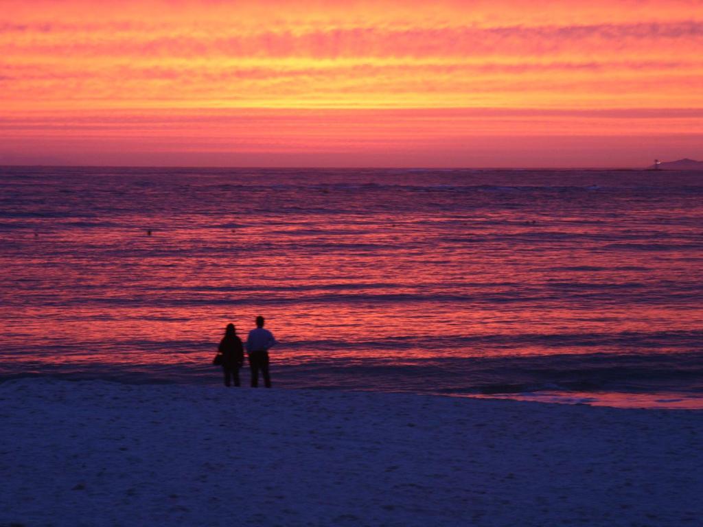 2 personnes debout sur la plage au coucher du soleil dans l'établissement Hotel Sanrakuso, à Shirahama