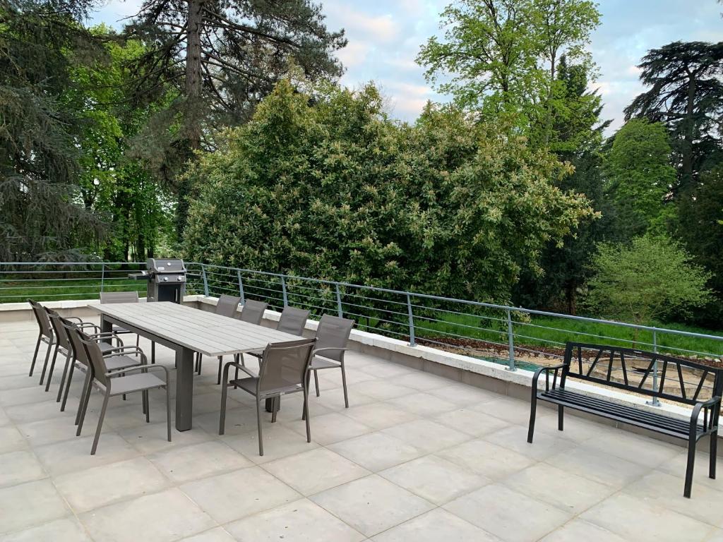 une table et des chaises assises sur une terrasse dans l'établissement Gîte « Les Basse des Grouets », à Blois