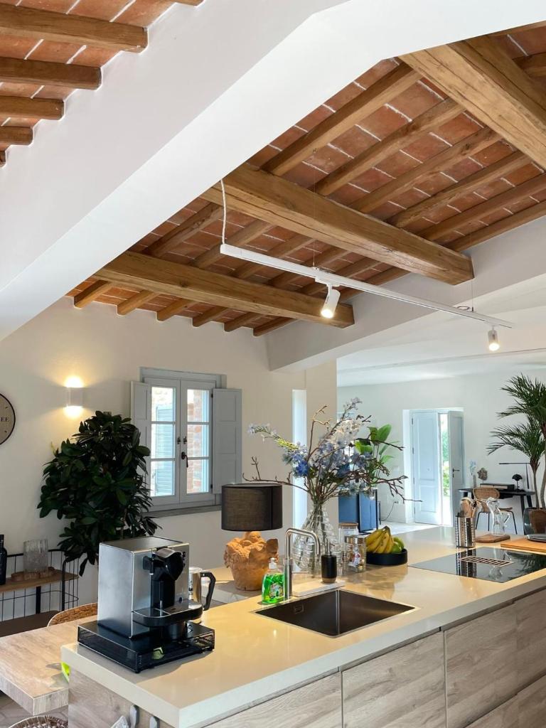 une cuisine avec des plafonds en bois et un comptoir avec une cafetière dans l'établissement Villa la Madonna with pool and padelcourt, à Monte del Lago