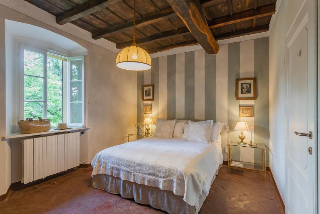 une chambre avec un lit avec un mur rayé dans l'établissement Villa Riva Bellagio with Pool & Garden by Rent All Como, à Bellagio